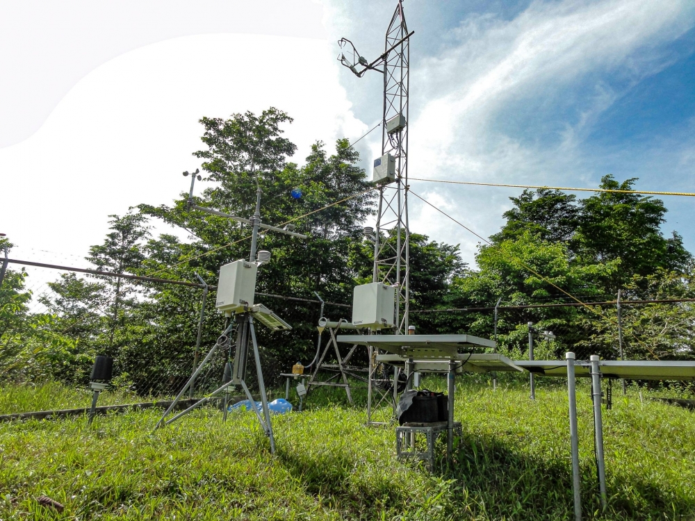 A 12 meter tall metal tower with trees in the background.