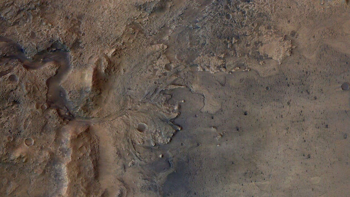 Aerial view of red and black land with a crater.