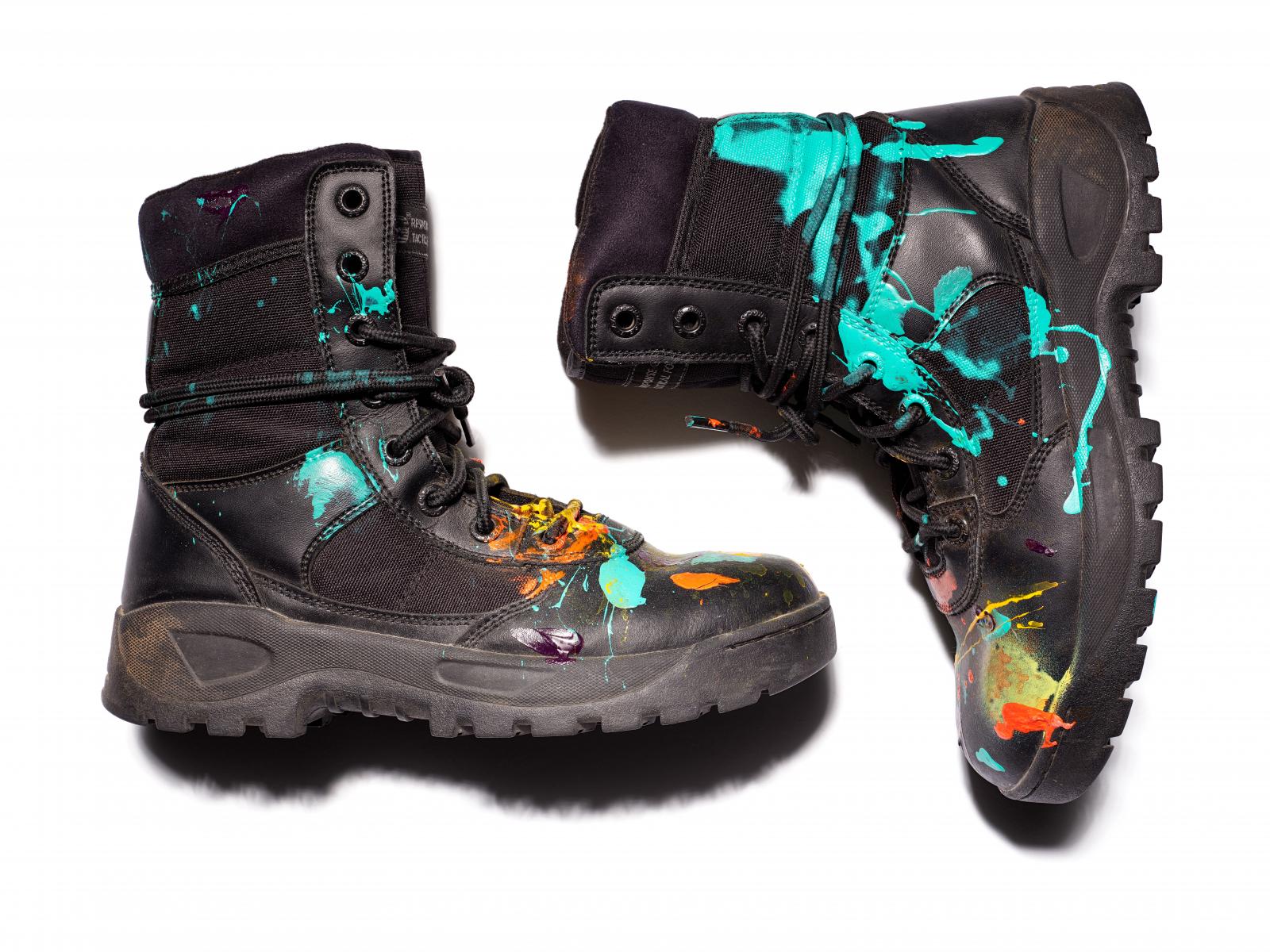 Black boots splattered with multiple colors of paint