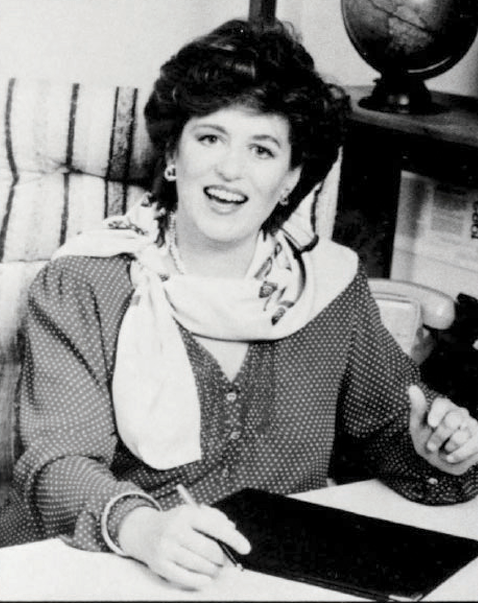 black and white photo of woman sitting at desk