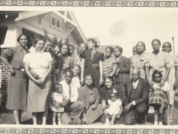 family portrait in front of a bungalow style home