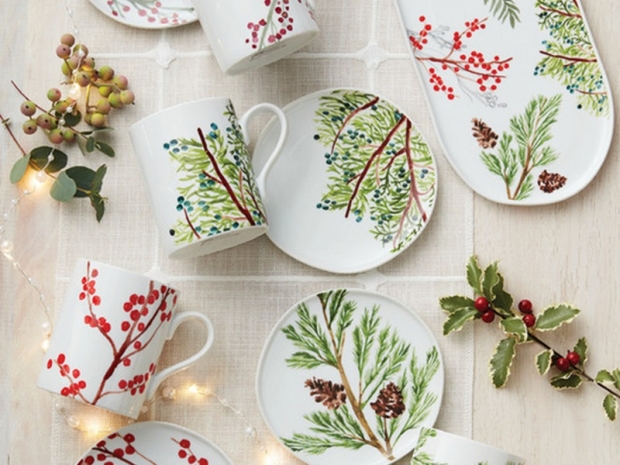 Top-down view of a holiday tablescape with decorative plates and mugs.
