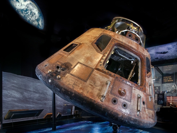 view of the moon command module with a photo of an earthrise in the background