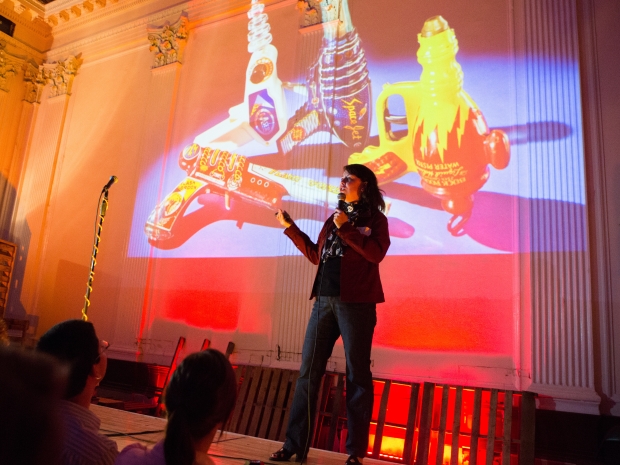 woman speaking with toy planes behind her