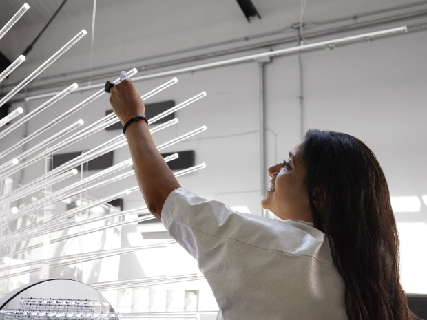 Woman smiles while installing artwork