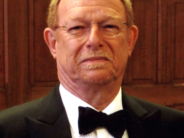 A man in a tuxedo smiles for a photo. 