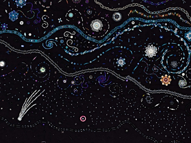 beads sewn on a black cloth with stars and the Milky Way