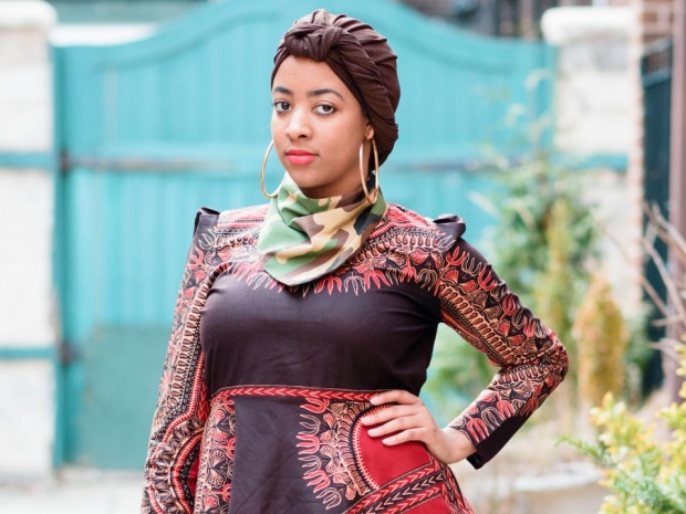 woman wearing tunic, pants, headwrap, and neck scarf.
