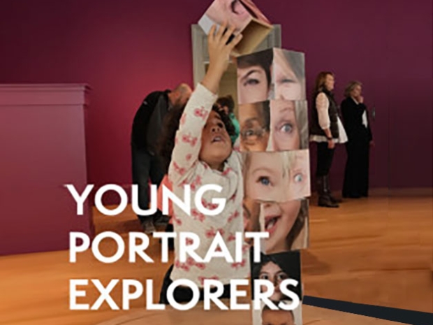 A young girl stacks a tower of blocks covered in faces.