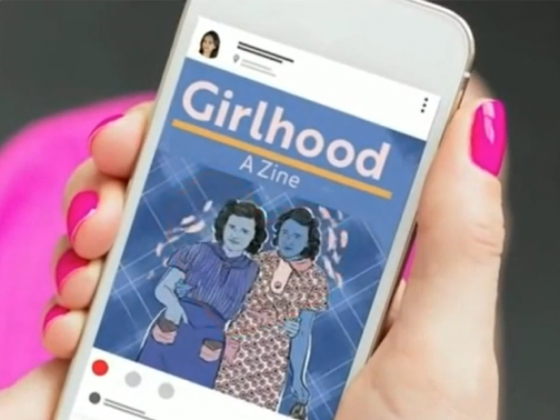 woman with pink nail polish holds a mobile phone with the Girlhood Zine