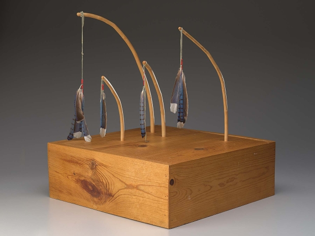 Wooden sculpture with a thick square base and thin bent sticks