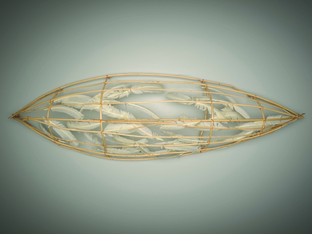 A sculpture in the shape of the canoe with white feathers.