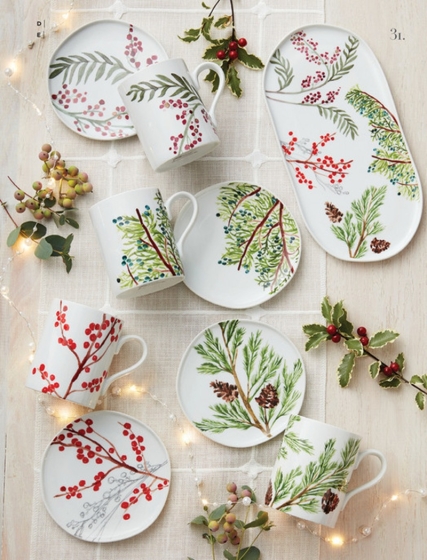 Top-down view of a holiday tablescape with decorative plates and mugs.