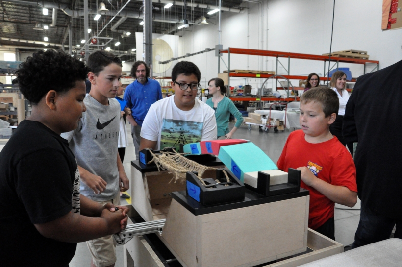 Children gather around activity table